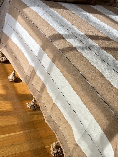 Handmade printed throw with beige, white, and black pompoms 110" x 79"