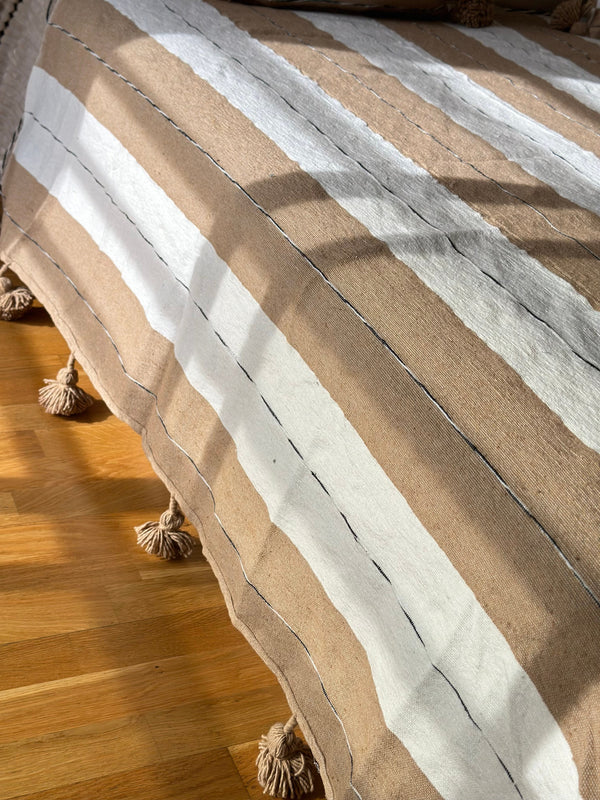 Handmade printed throw with beige, white, and black pompoms 110" x 79"