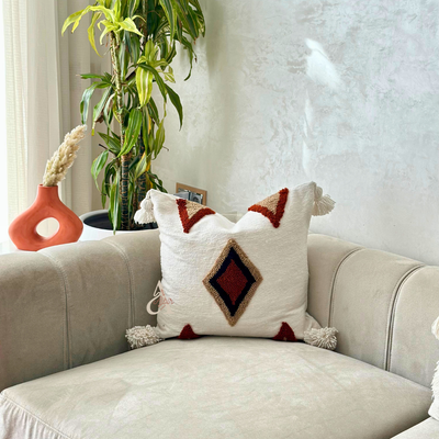 Handmade cushion cover with terracotta pompoms