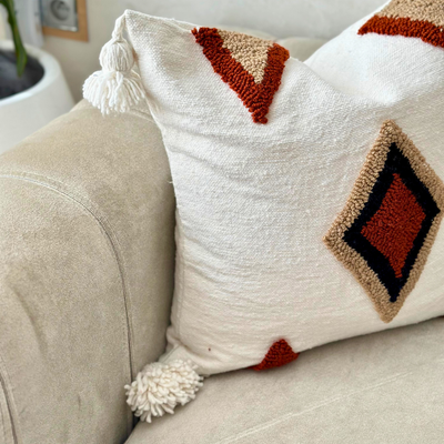 Handmade cushion cover with terracotta pompoms