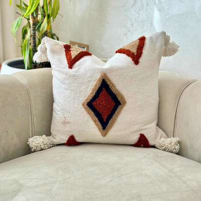 Handmade cushion cover with terracotta pompoms