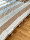Handmade printed throw with beige, white, and black pompoms 110" x 79"