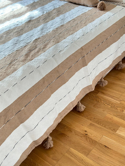 Handmade printed throw with beige, white, and black pompoms 110" x 79"