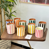 Light orange striped handmade terracotta candle with Amber scent